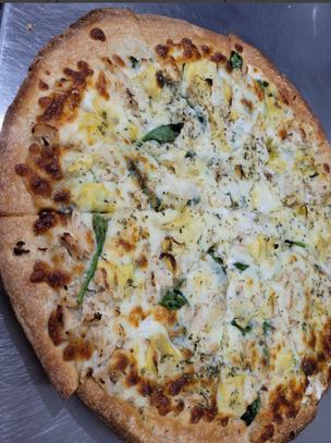 A round pizza topped with artichoke, spinach and white sauce at Charlie's Pizza