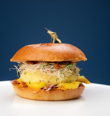 A breakfast sandwich with egg and sprouts on a round roll from Egg On A Roll in Sioux Falls