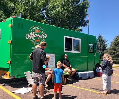 Murph's Burgers green food truck with customers gathered outside