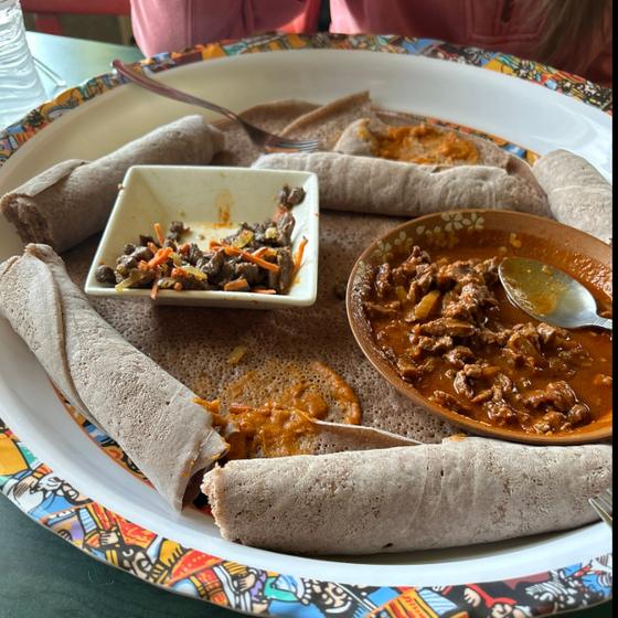 Ethiopian dishes served with injera on a colorful patterned platter at Shalom Coffee House