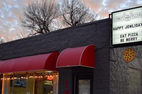 Storefront of Sunny's Pizzeria in Sioux Falls with red awnings and a marquee sign