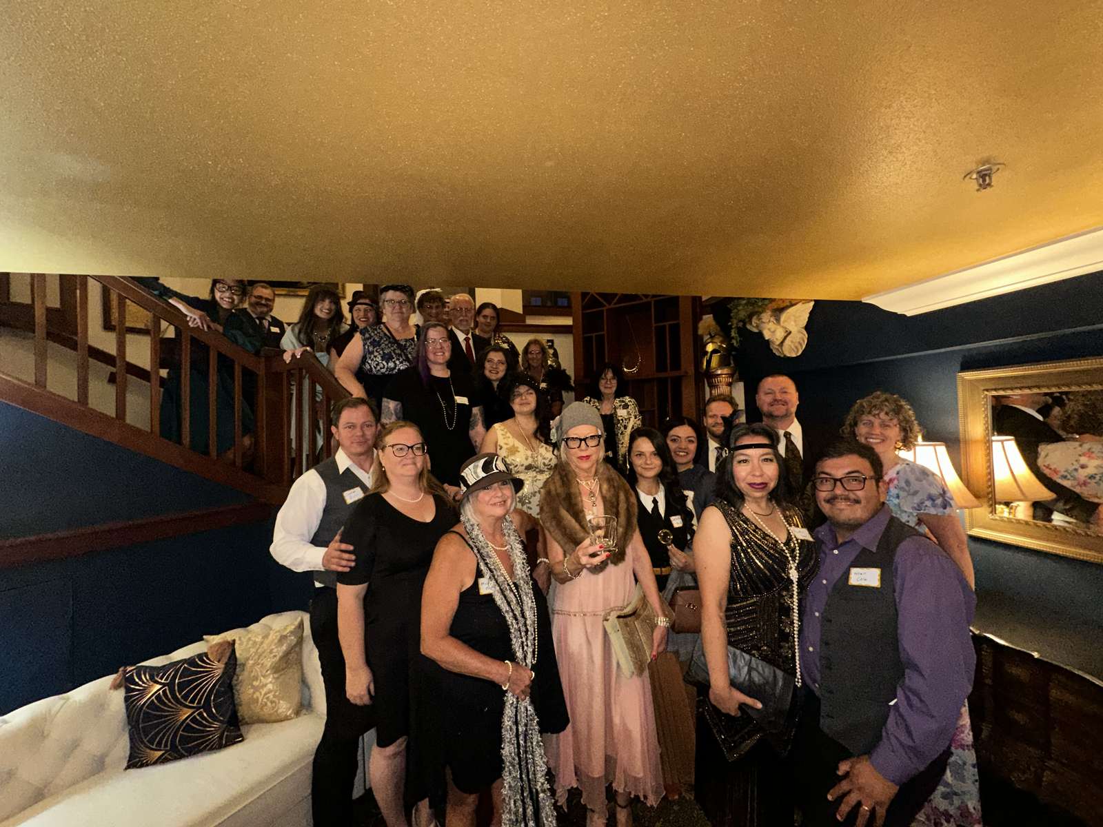 A group of costumed guests gathered together on a staircase