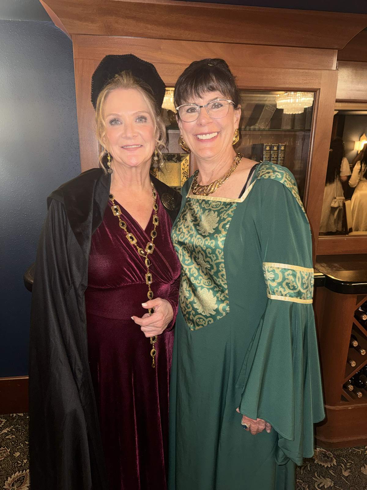 Two guests in elegant costume robes standing together